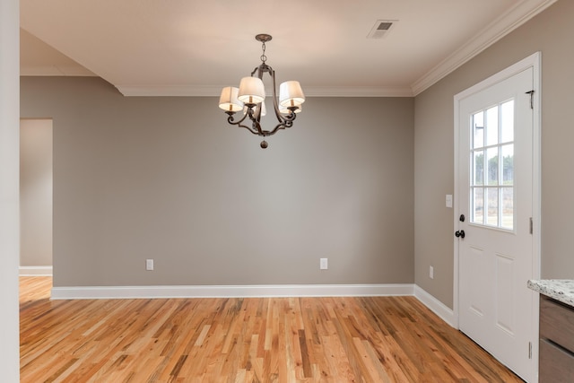 interior space with light wood-type flooring, an inviting chandelier, and ornamental molding