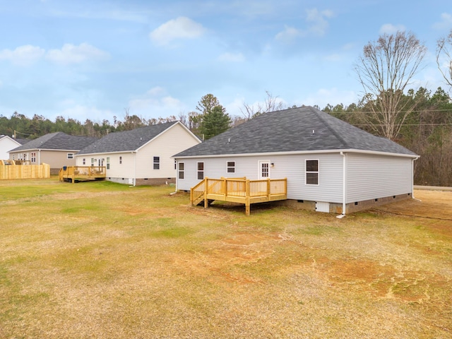 rear view of house featuring a deck and a lawn