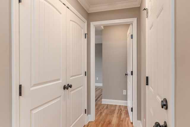 hallway featuring light wood-type flooring and ornamental molding