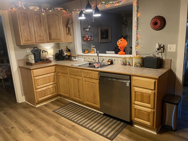 kitchen with tile counters, dark wood-style flooring, dishwasher, and a sink