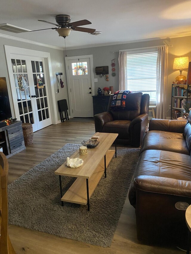 living room with ceiling fan, wood finished floors, crown molding, and french doors