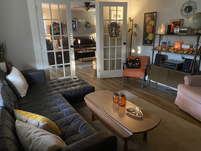 living area with a ceiling fan, french doors, and wood finished floors