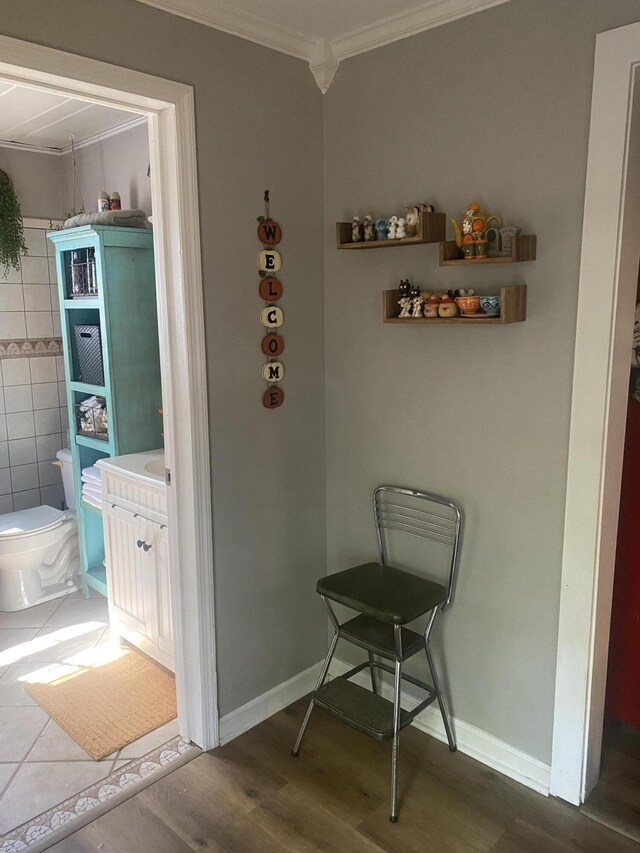 interior space with baseboards, wood finished floors, and crown molding