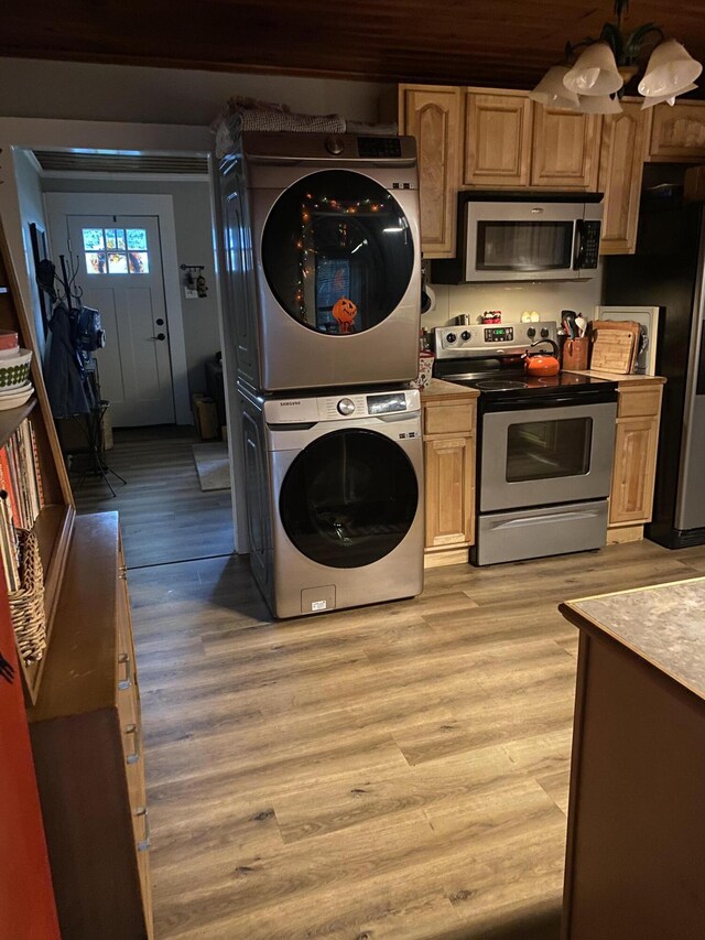 kitchen featuring light wood-type flooring, light brown cabinets, stainless steel appliances, and stacked washer and clothes dryer