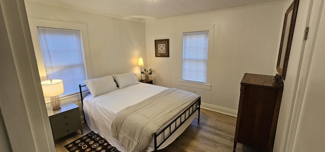 bedroom with dark wood-type flooring and ornamental molding