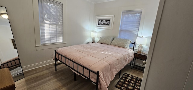 bedroom with dark hardwood / wood-style flooring and ornamental molding