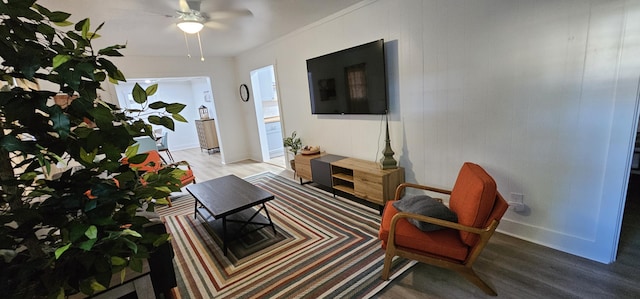 living room featuring hardwood / wood-style flooring, ceiling fan, and ornamental molding