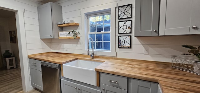 kitchen featuring wood counters, gray cabinets, and stainless steel dishwasher