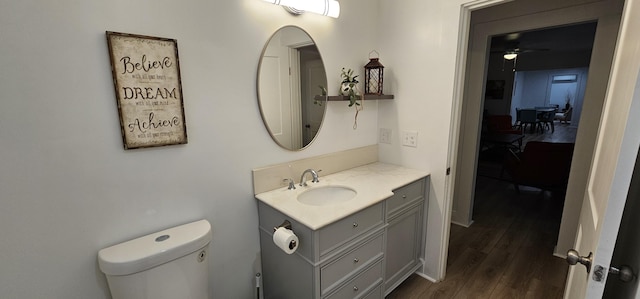 bathroom with vanity, hardwood / wood-style flooring, toilet, and ceiling fan