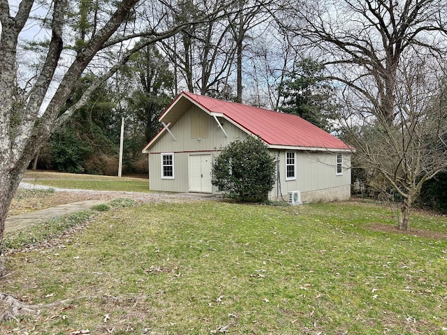 view of property exterior with a yard and an outbuilding