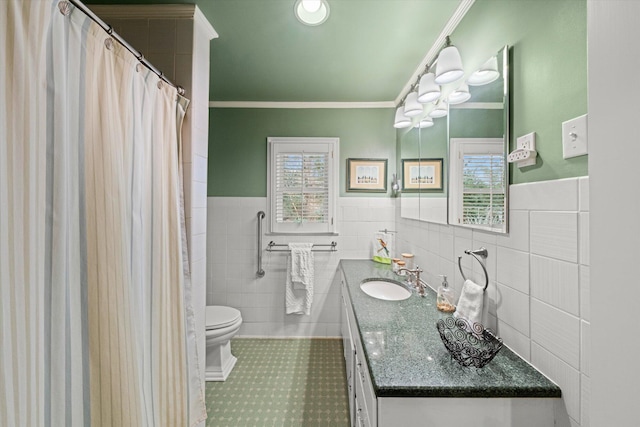 bathroom featuring ornamental molding, toilet, vanity, and a wealth of natural light