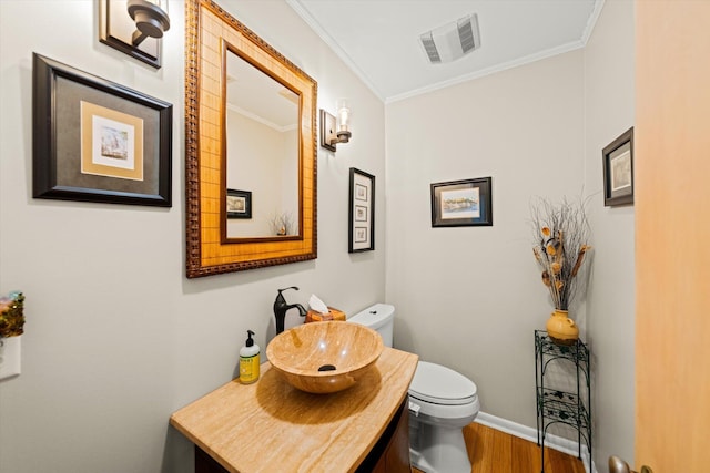 bathroom featuring crown molding, vanity, toilet, and hardwood / wood-style floors