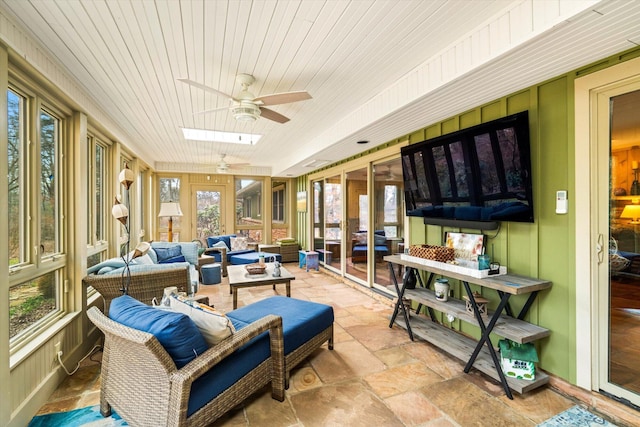 sunroom / solarium featuring wood ceiling, ceiling fan, and a skylight