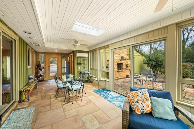 sunroom featuring wood ceiling, a skylight, an AC wall unit, and ceiling fan