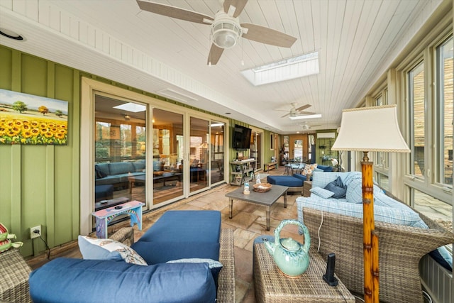 sunroom / solarium featuring wood ceiling, ceiling fan, and a skylight