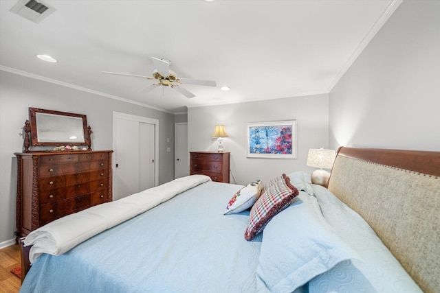 bedroom featuring crown molding, hardwood / wood-style floors, ceiling fan, and a closet