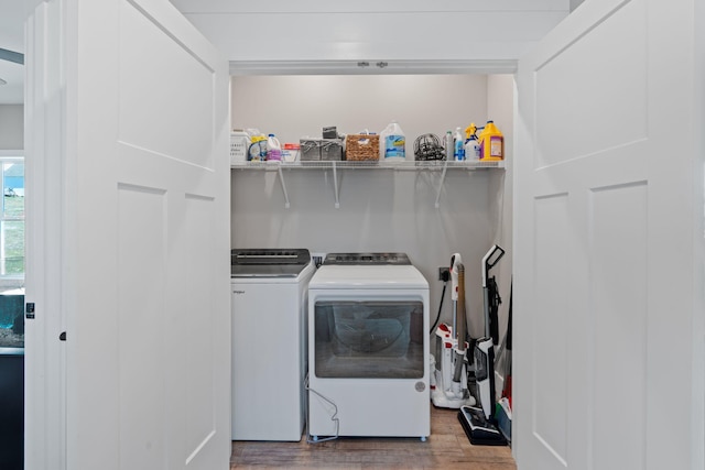 washroom featuring laundry area, washing machine and dryer, and wood finished floors