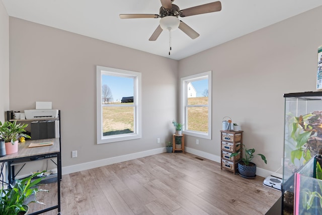 interior space with ceiling fan, baseboards, and wood finished floors