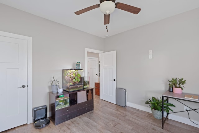 office area with light wood-type flooring, baseboards, and a ceiling fan