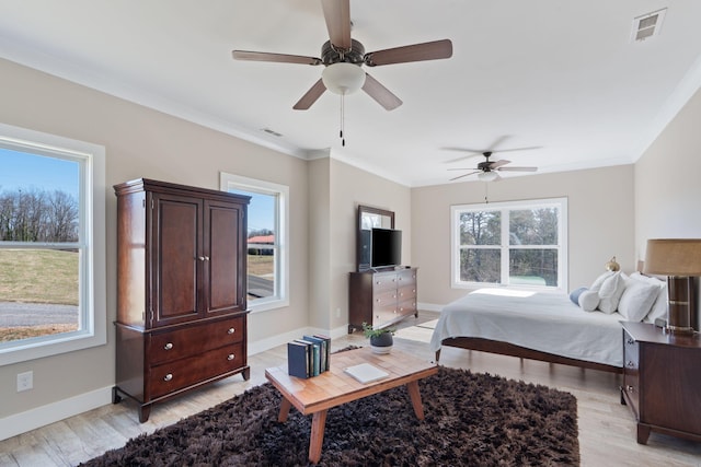 bedroom featuring ornamental molding, visible vents, light wood-style flooring, and multiple windows