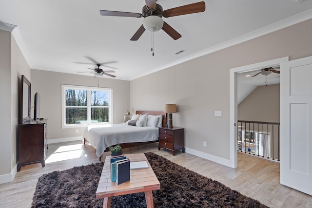 bedroom with baseboards, light wood-style floors, visible vents, and crown molding