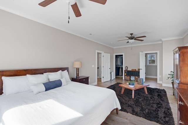 bedroom with crown molding, baseboards, and light wood-style floors