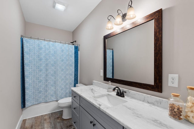 full bath with shower / bath combo, vanity, toilet, and wood finished floors