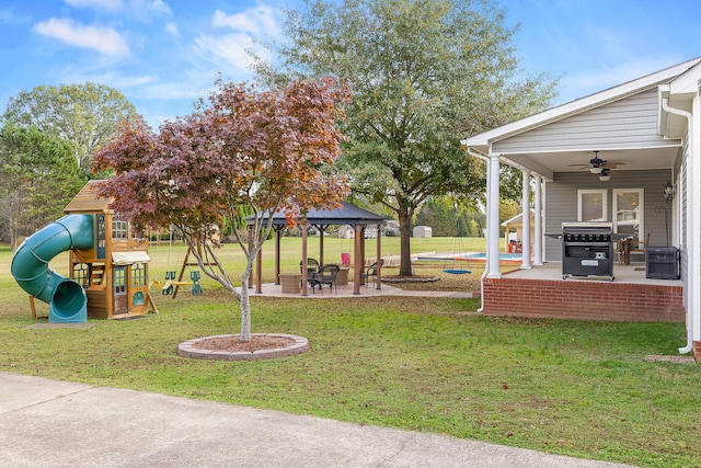 view of yard featuring a gazebo, ceiling fan, a patio area, and a playground