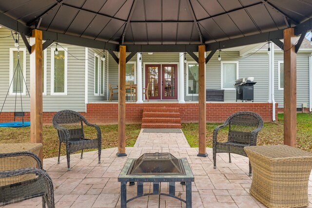 view of patio with a gazebo, an outdoor fire pit, and french doors