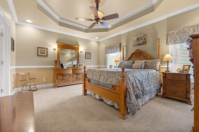 bedroom featuring carpet, a tray ceiling, ceiling fan, and crown molding