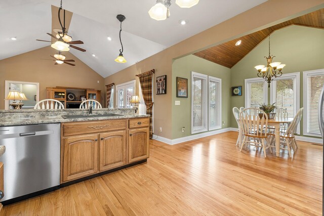 kitchen with stainless steel dishwasher, light stone countertops, light wood-type flooring, and sink