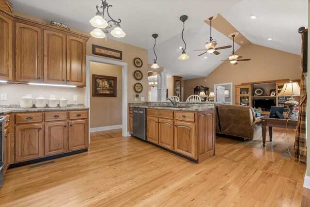 kitchen with stainless steel dishwasher, decorative light fixtures, light wood-type flooring, and lofted ceiling