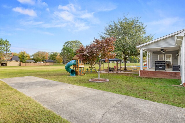 view of yard featuring a playground, a patio area, ceiling fan, and a gazebo