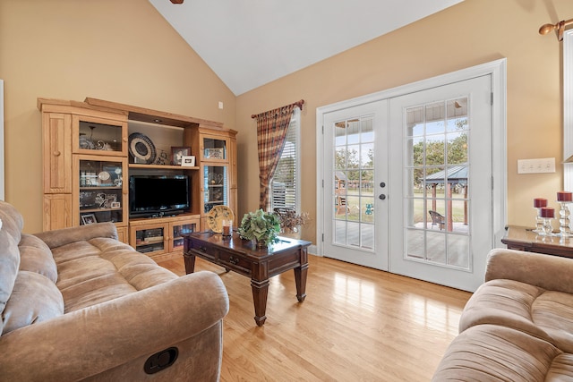 living room with french doors, high vaulted ceiling, and light hardwood / wood-style floors