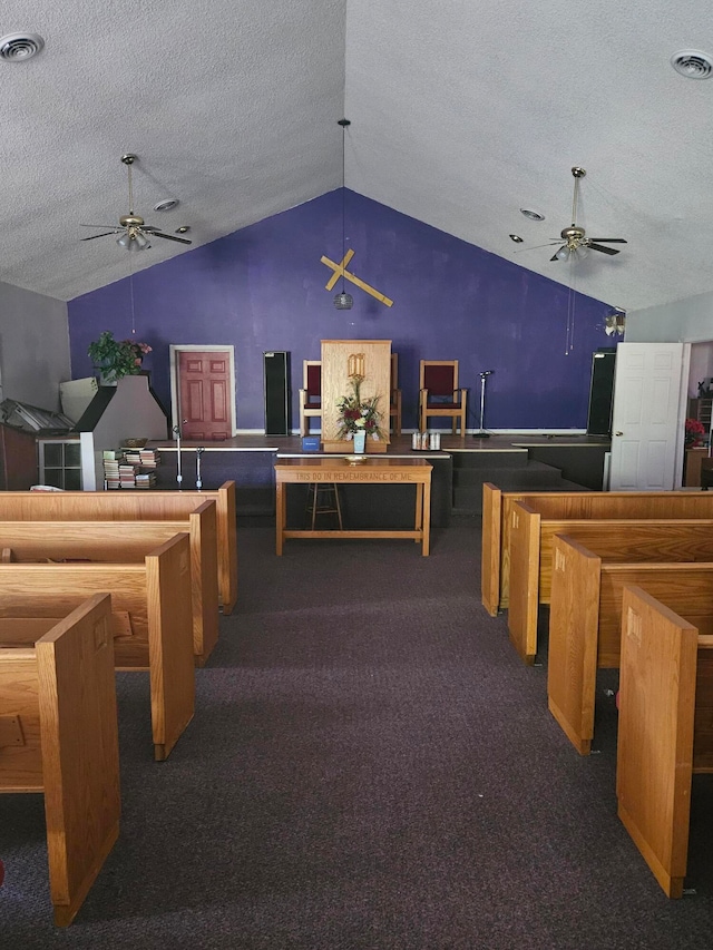 rec room with a textured ceiling, ceiling fan, lofted ceiling, and dark colored carpet