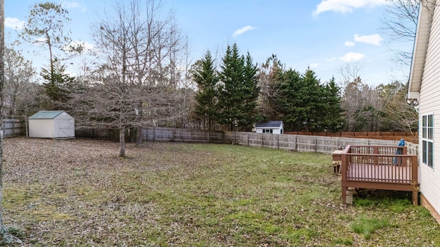 view of yard with a wooden deck and a storage shed