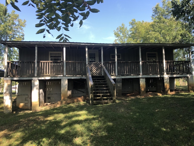 rear view of property featuring stairway, board and batten siding, and a yard