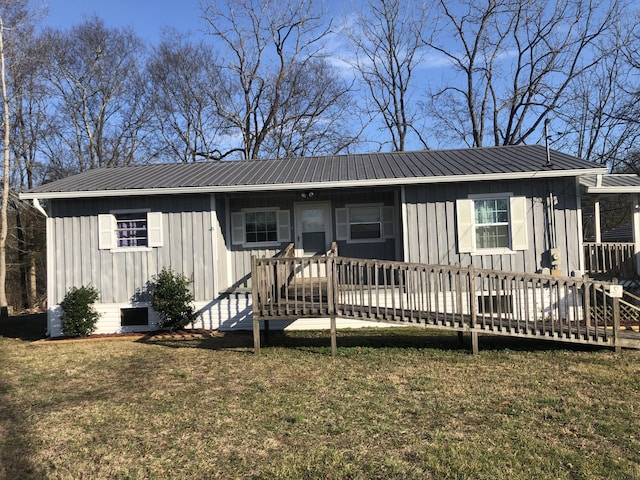 view of front of property featuring metal roof, board and batten siding, and a front yard