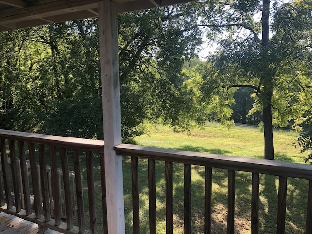 wooden deck featuring a lawn