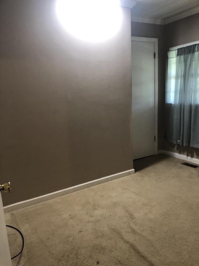 spare room featuring carpet, visible vents, and baseboards