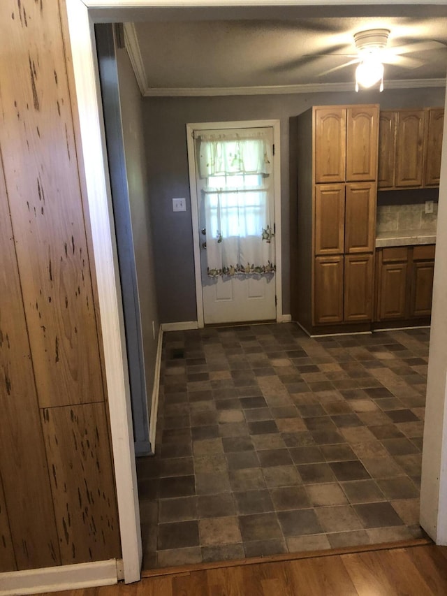 doorway to outside featuring ornamental molding and baseboards