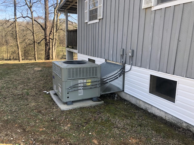 exterior details featuring board and batten siding and cooling unit