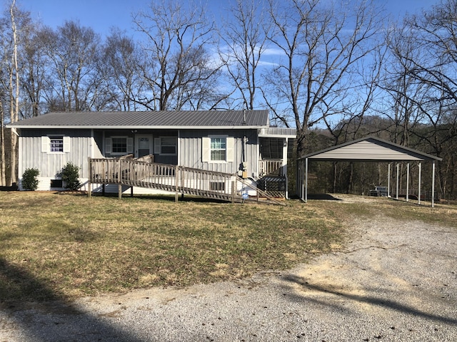 view of front of property with a deck, metal roof, a carport, board and batten siding, and a front yard