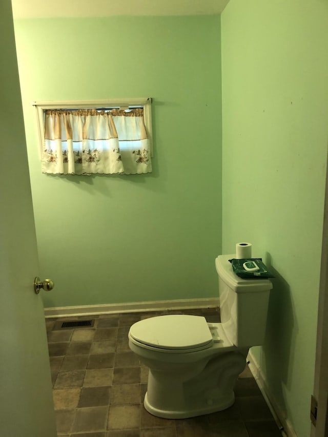 bathroom featuring toilet and baseboards