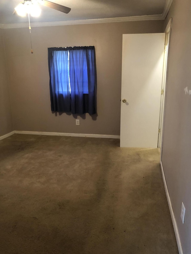 carpeted empty room featuring ornamental molding, ceiling fan, and baseboards