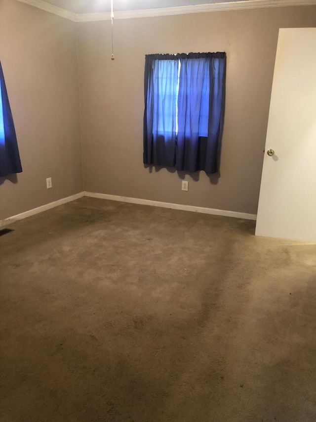 interior space featuring carpet floors, visible vents, baseboards, and crown molding