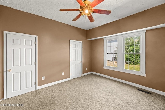 unfurnished bedroom featuring ceiling fan, carpet floors, and a textured ceiling