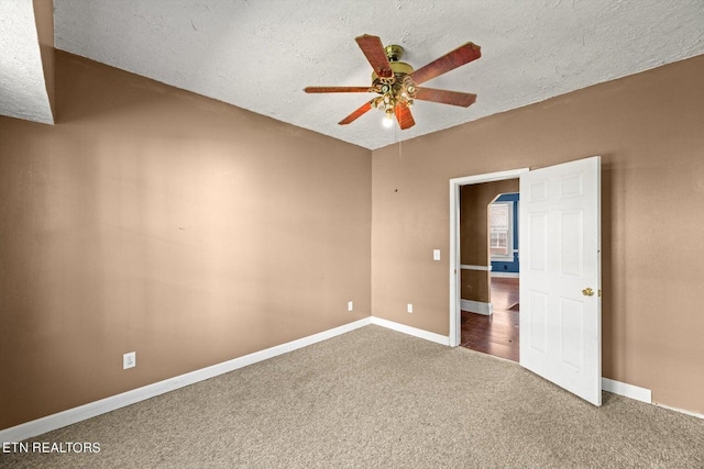 carpeted empty room with ceiling fan and a textured ceiling