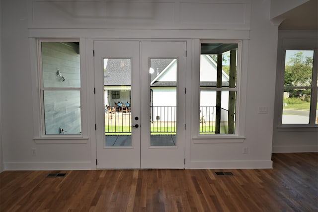 doorway featuring plenty of natural light, wood finished floors, visible vents, and baseboards