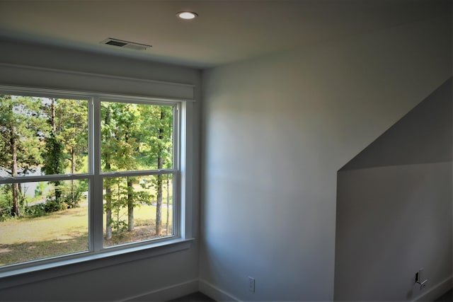 spare room with recessed lighting, a healthy amount of sunlight, and visible vents